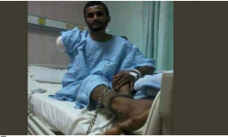 صورة صادمة.. الشرطة السعودية تكبل عاملا يمنيا بالسلاسل على سرير المرض!